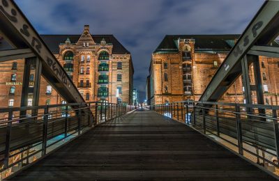 同城跑腿骑手在城市中快速配送，背景是现代化写字楼群，蓝色主题专业感